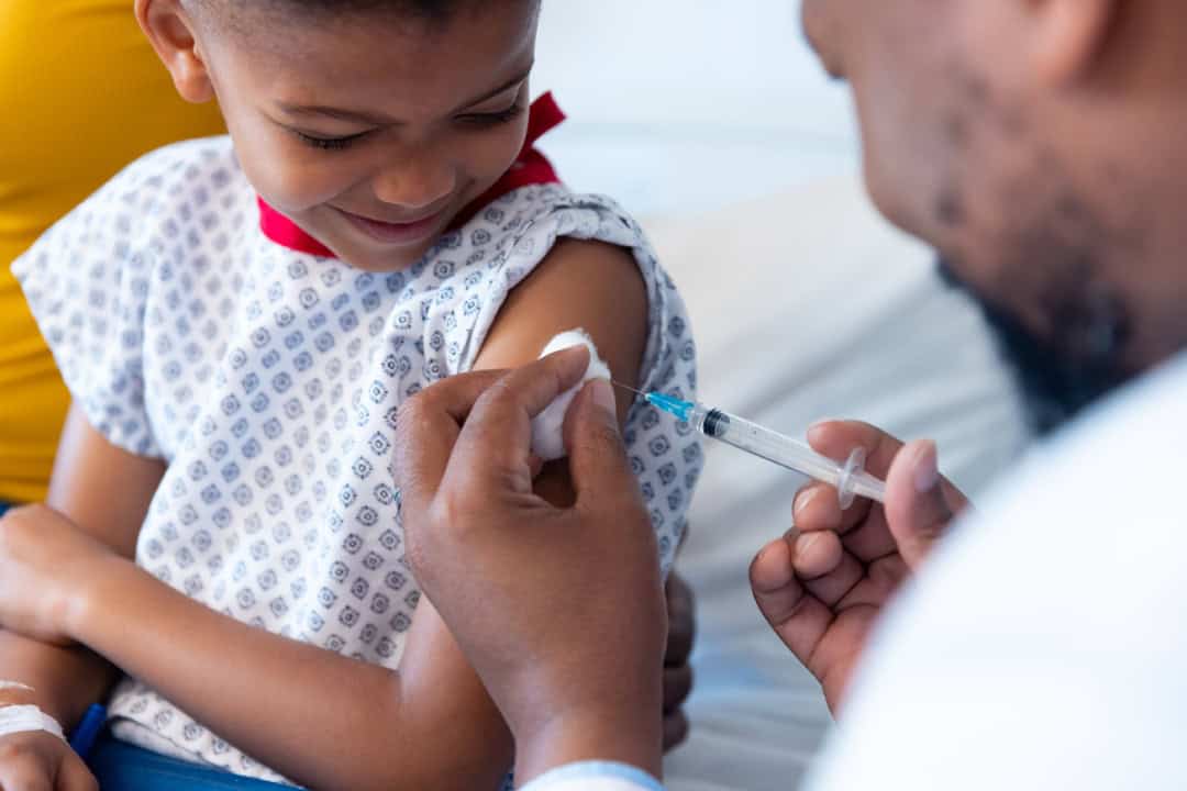 african american male doctor vaccinating a boy pat min
