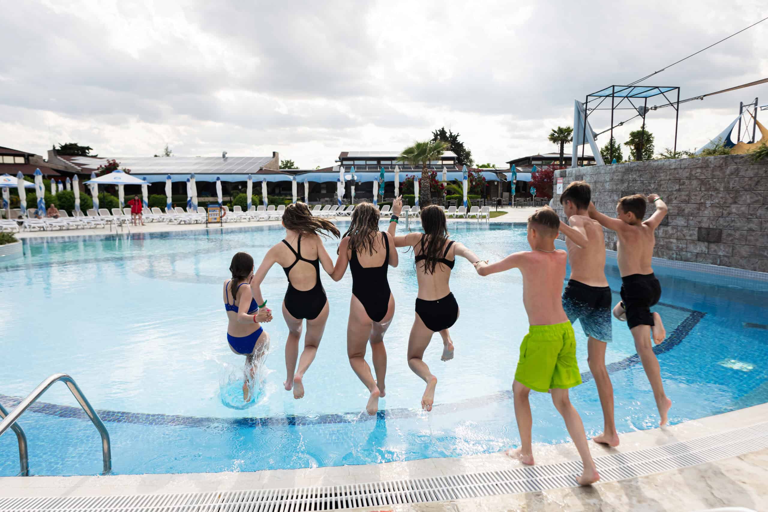 group of friends jumping into swimming pool summe 2025 02 11 01 34 32 utc scaled